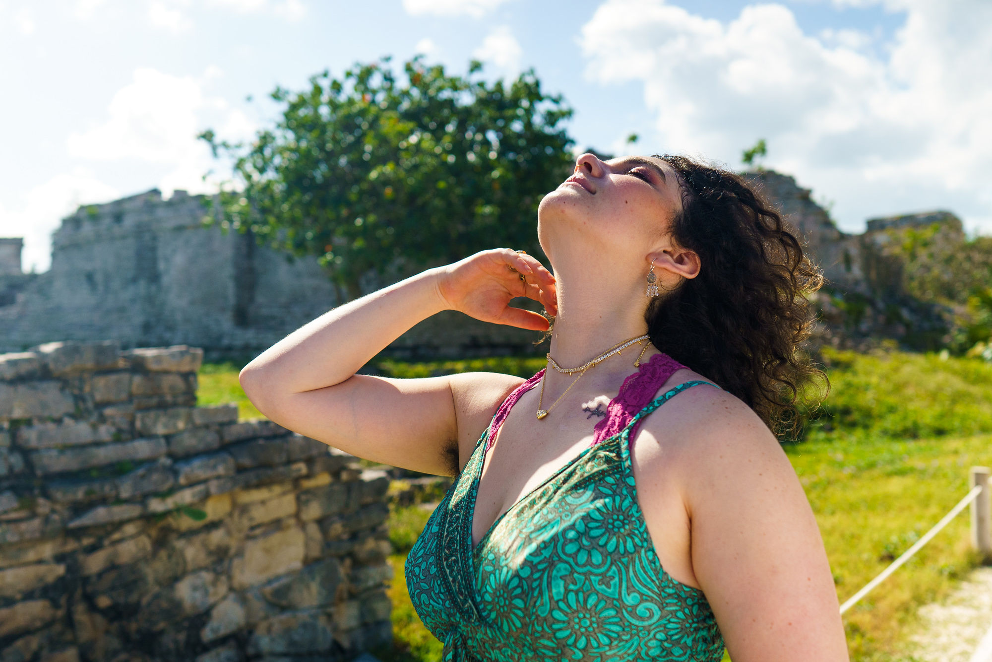 Breena in peaceful vocal practice outdoors, head tilted back in authentic expression surrounded by nature
