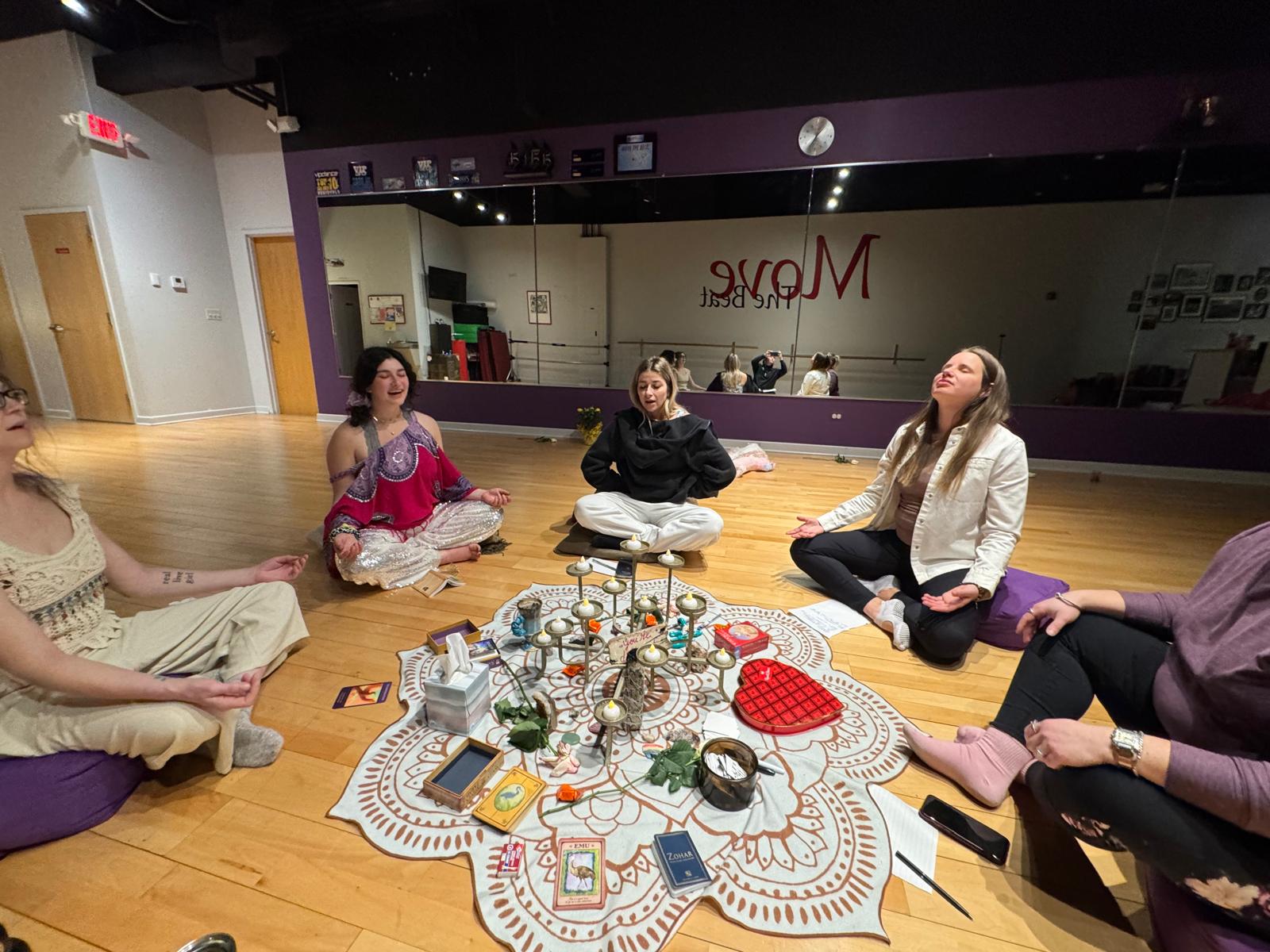 Breena leading a group workshop with participants in a sacred circle, engaging in voice and movement practices